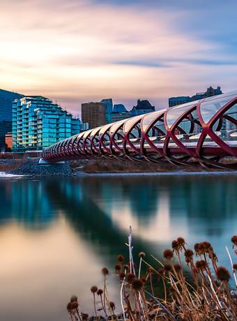 Calgary’s Peace Bridge alongside a bustling urban skyline, reflecting a smooth transition, akin to our dedicated moving services.