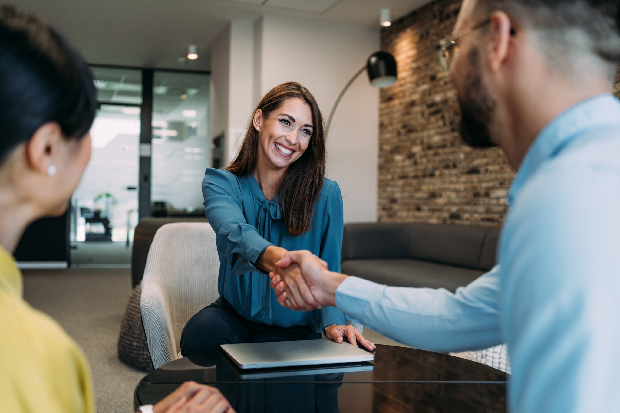 A Canadian Preferred Moving representative happily shaking hands with a client, symbolizing excellent customer service.