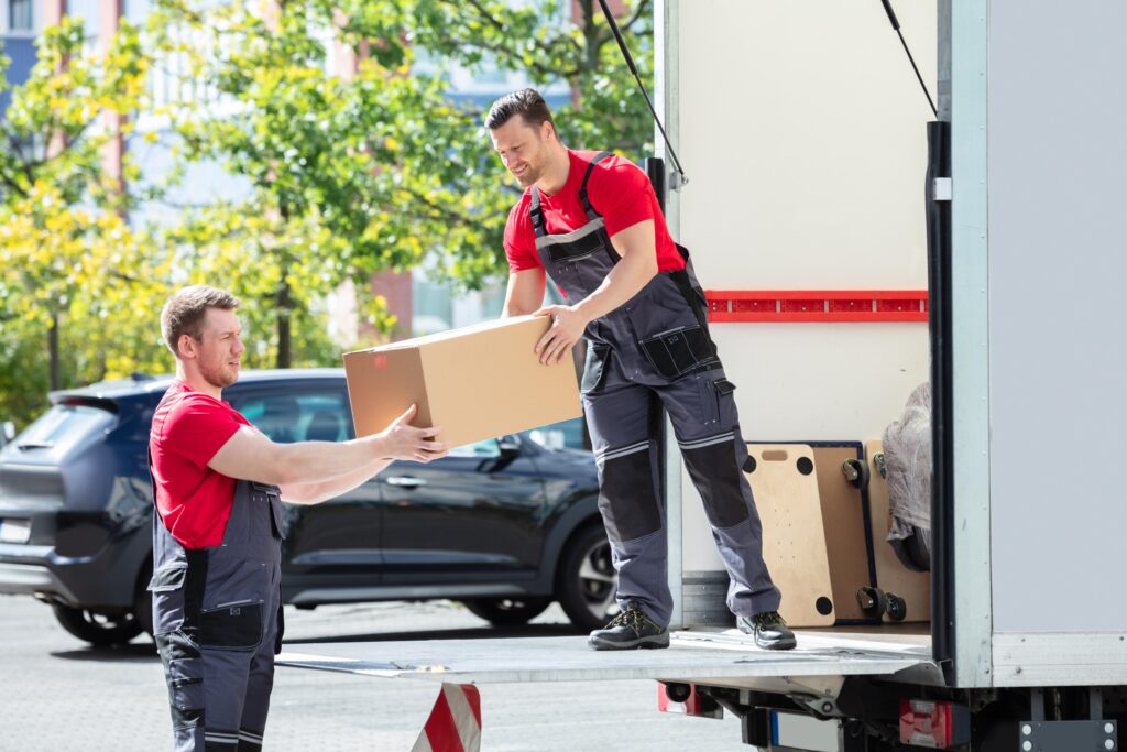 Team of professional movers loading moving boxes inside a truck