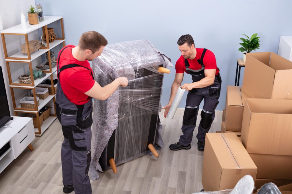 CPM Professional movers wrapping a couch with protective plastic for a long distance move