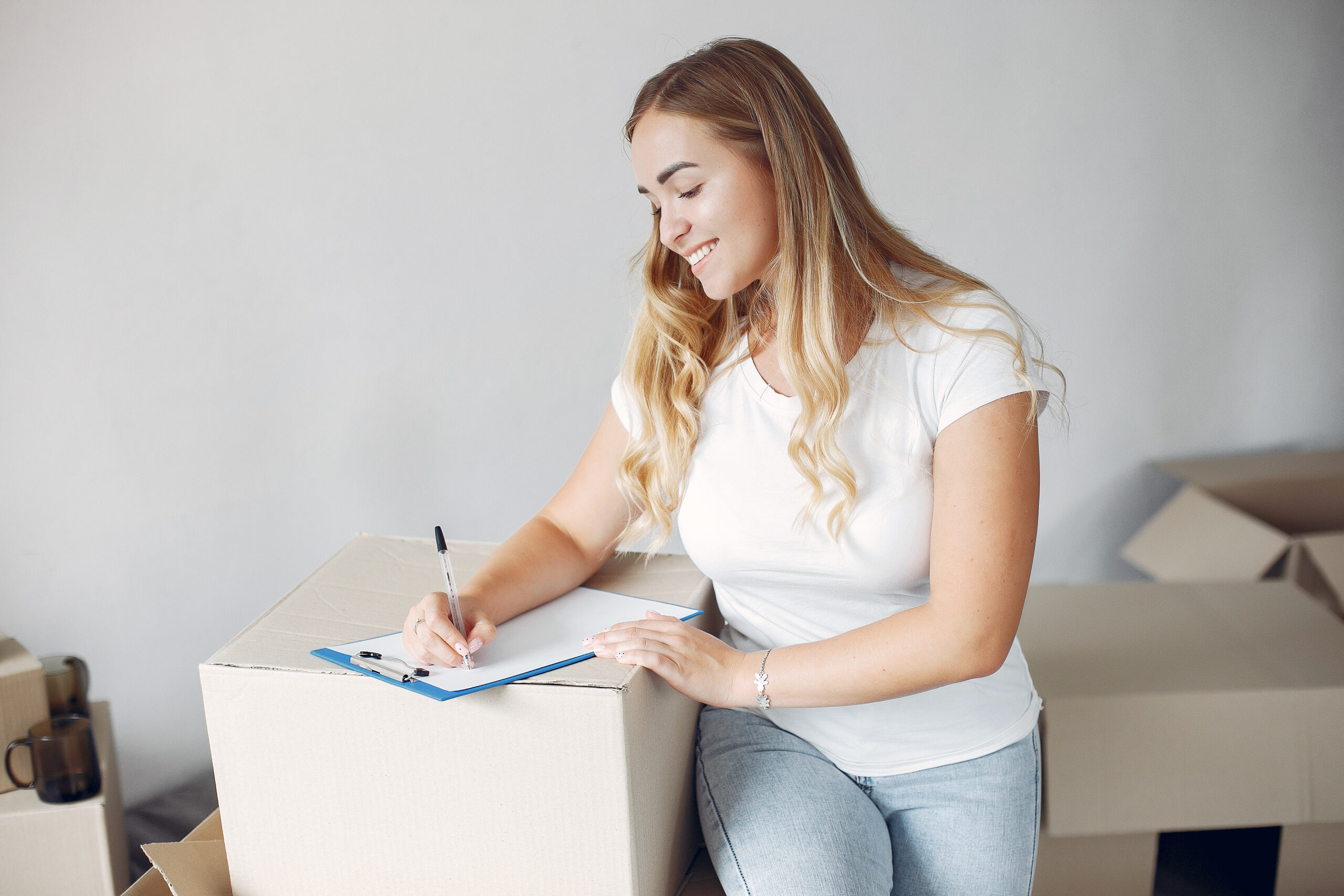 Woman checking a printed moving checklist to a customer in their home