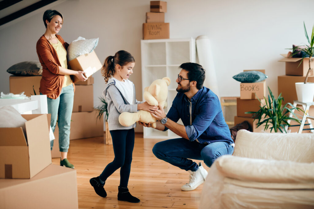 Happy father and daughter having fun while moving into a new apartment.