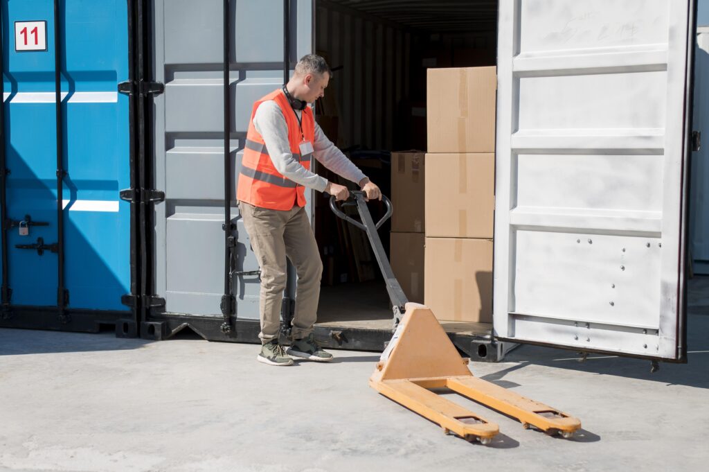 Man carrying pallet into a moving container