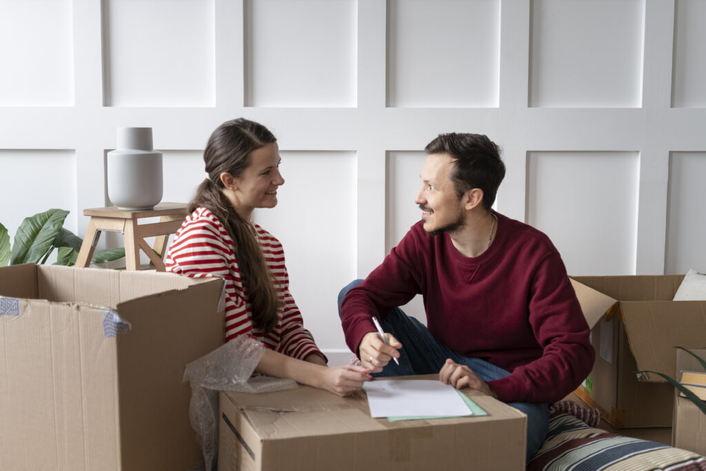 Young couple packing boxes and making a checklist while preparing to move to a new home